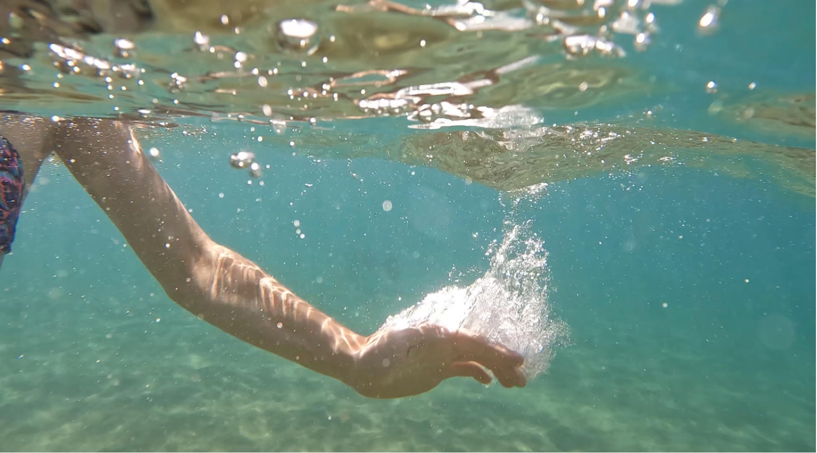 Une main effleurant la surface de l'eau